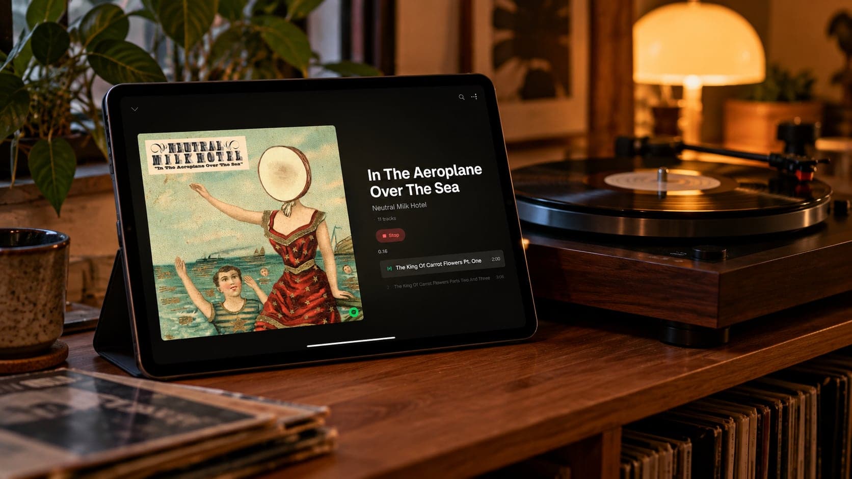 An AI-generated image: a tablet on a wooden sideboard beside a turntable, showing StackedFM playing In the Aeroplane Over the Sea by Neutral Milk Hotel.