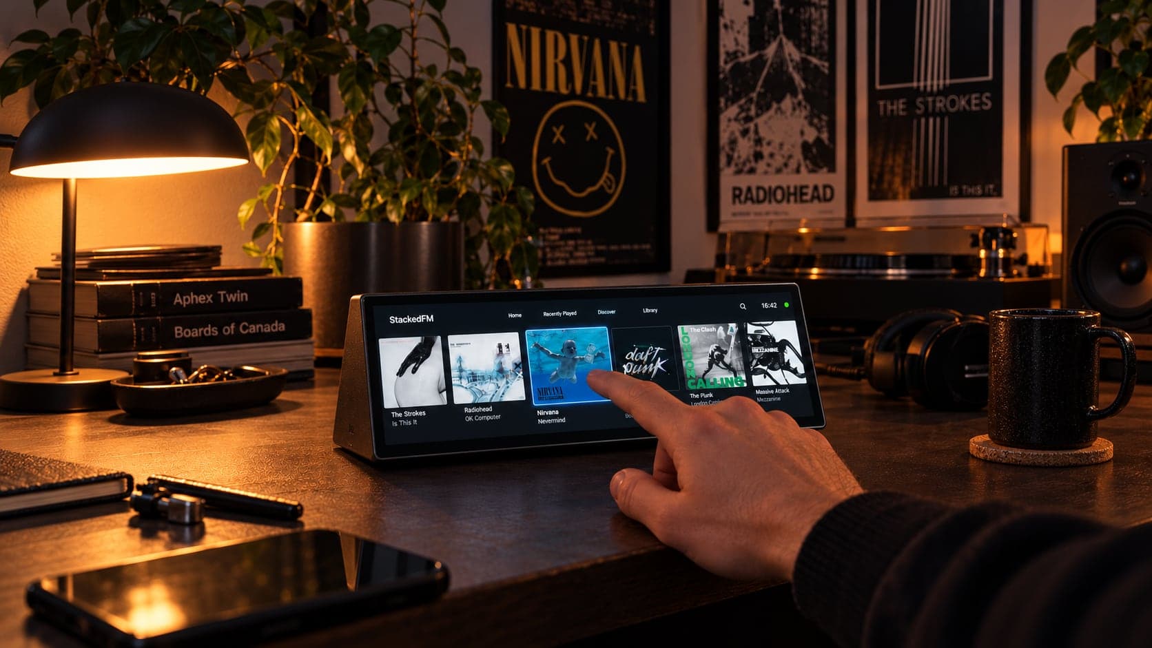 An AI-generated concept image: a long, wedge-shaped touchscreen on a dark desk showing a row of album covers, with a finger touching Nirvana's Nevermind, and band posters on the wall behind it.